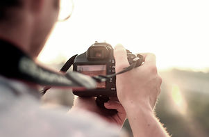 An image of a photographer looking at the camera to take a photo