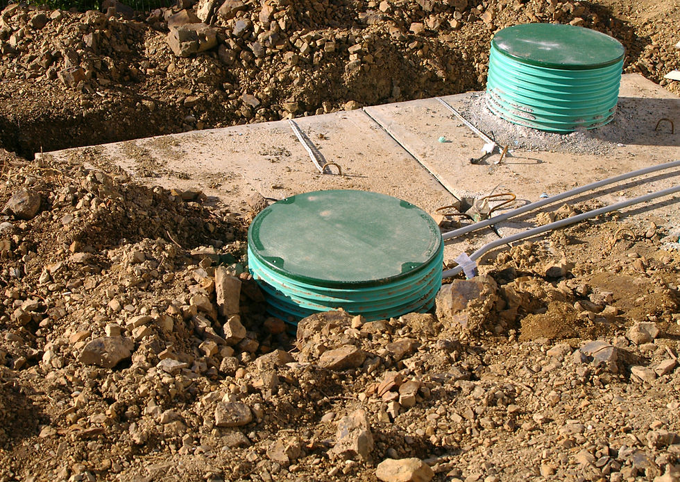 In-ground septic system showing two green riser access lids protruding from soil