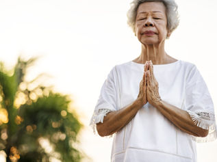 Une dame âgée qui fait de la sophrologie ou médite pour gérer son stress et ses émotions dans le cadre d'un accompagnement en naturopathie