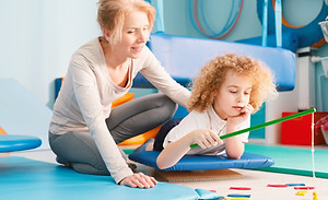 Focused kid having sensory integration session with professional therapist