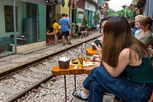 Couple vietnamien buvant une bière à côté d'une voie ferrée.