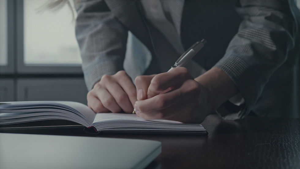 Person Writing in Notebook