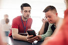 teacher in leadership training sows student how to do something on the phone