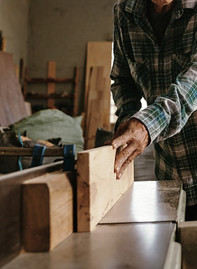Old Asian carpenter cutting wood