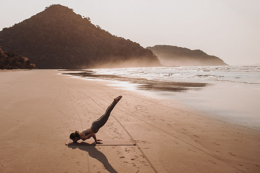 De yoga stelt op het strand