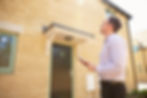 Male real estate agent looking up at a house exterior