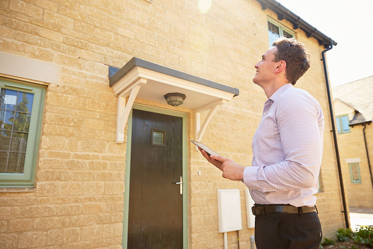 Male real estate agent looking up at a house exterior