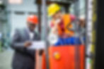 Logistics supervisor and forklift operator reviewing shipment documents