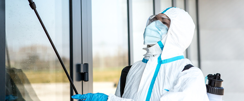Staff in clean suits disinfecting contaminated area