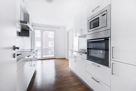 Modern narrow white kitchen with integrated oven