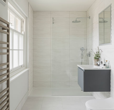 Modern, minimal, wet room with floating vanity unit, glass shower screen adn wall mounted