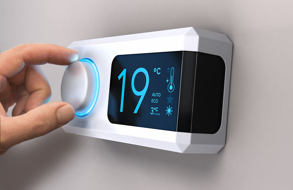 close-up image of a person's hand while adjusting temperature in thermostat