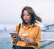 コーヒーとタブレットを持つ女性