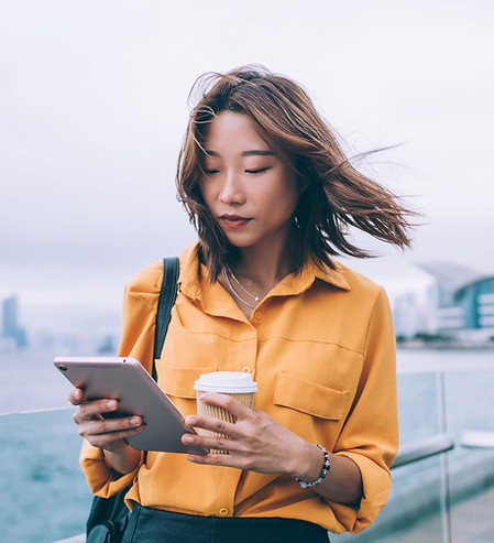 コーヒーとタブレットを持つ女性