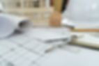 Hands holding a pencil and ruler over architectural blueprints, exuding focus