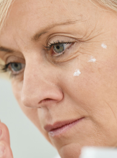 Mulher aplicando creme facial