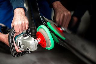 Working repairing quarter panel with a portable handheld polisher