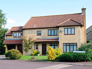 Front view of a newly built detached house with a landscaped garden