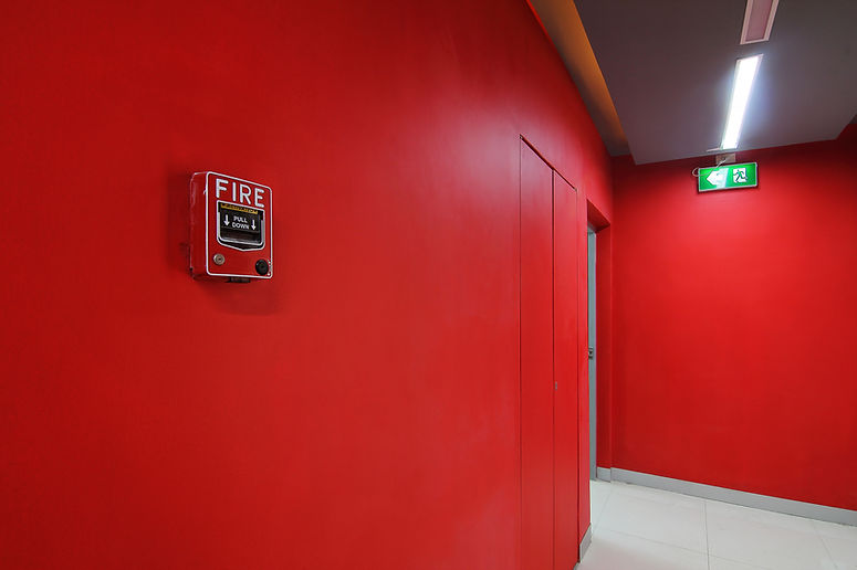 Emergency exit of the building with fire exit sign and fire alarm