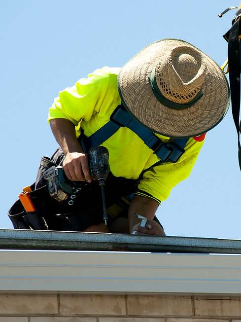 Roofing contractor installing materials on a residential roof - Outlaw Roofing crew performing roofing services in Mesa and the East Valley.
