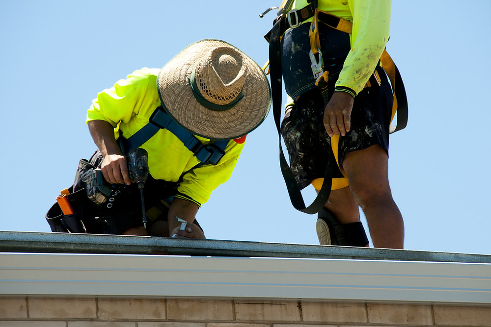 Two tradies working on a rooftop together