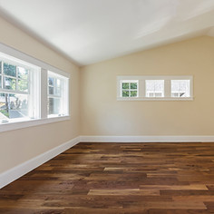 Modern living space featuring freshly plastered walls and dark wood flooring