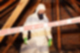 Man in protective gear removing asbestos material