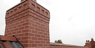 Red brick chimney stack on a residential roof