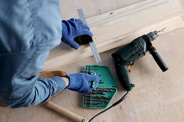 Gloved hands marking wood for window or door repair.