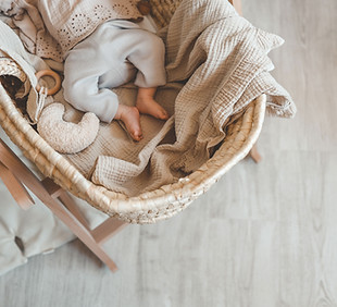 Baby in wicker cradle