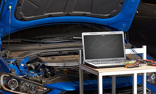 car engine with open bonnet and laptop