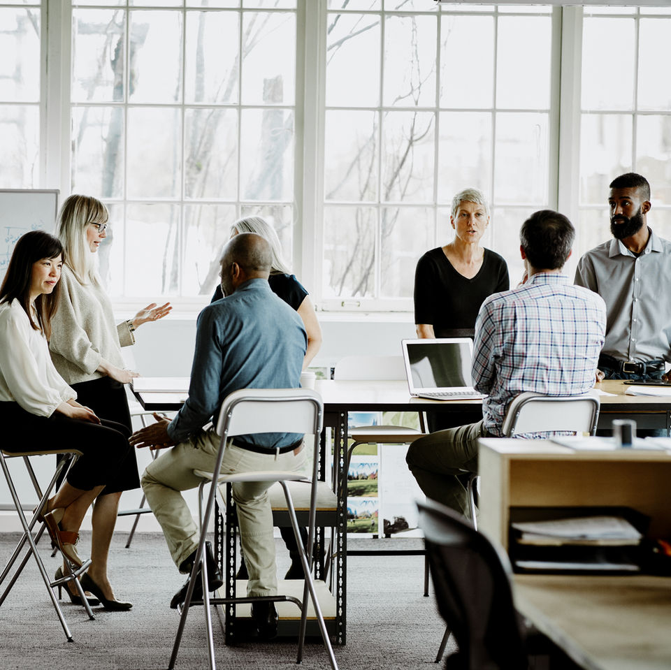 a group of people gathering around to brainstorm, explore and make a decision