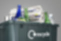 Recycling bin filled with waste paper and bottles close-up