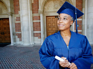 Graduate holding diploma outside university building, highlighting the need for verified qualifications to prevent workplace fraud.