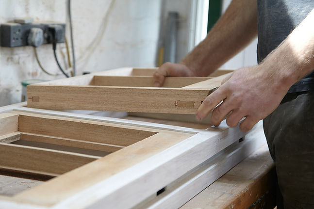 Close up of a professional carpenter precisely measuring and working on a timber joint