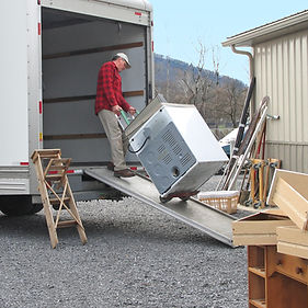 Man pulls dryer onto moving van using a dolly