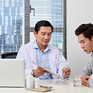 Asian doctor discussing and consulting for a male patient