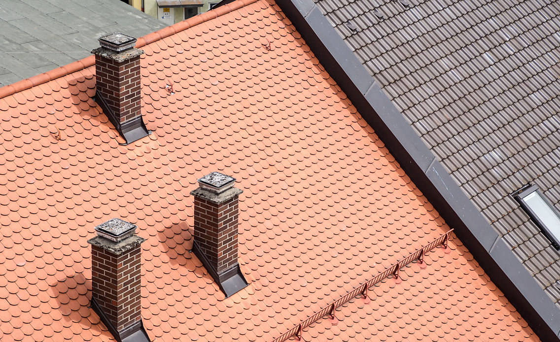 Aerial view of newly installed terracotta roof tiles and chimney in Plymouth