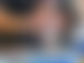 Hands assemble a small robot on a table with papers and a tablet. 