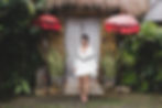 Young woman in white tunic in front of a traditional house in Bali