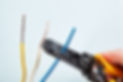 Electrician uses wire stripper tool during electrical wiring services