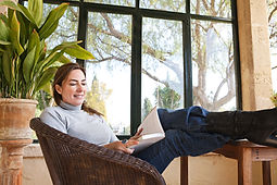 Attractive mature woman with her feet up on a table