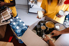 muted background of volunteers packing food pantry items