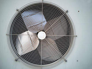 Close up front view of a clean circular industrial metal fan grille and internal extraction blades
