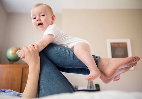 Mother Balancing Baby on Legs