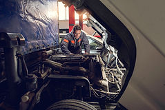 Auto mechanic working on a truck in a repair shop