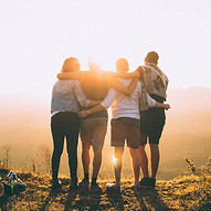 Gruppenumarmung bei Sonnenuntergang