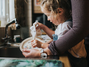 Mom and child cleaning dishes.