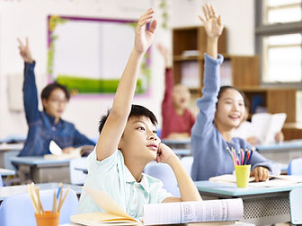 Kids Raising Hands In Classroom