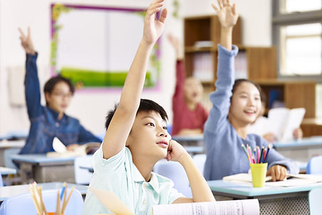Kids Raising Hands In Classroom
